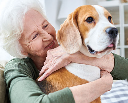 senior woman hugging her dog and smiling